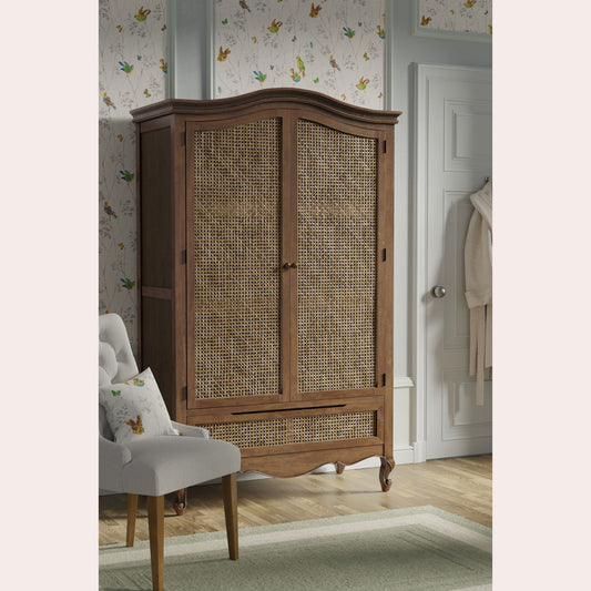 Walnut wardrobe with 2 rattan inset doors and single bottom drawer styled in bedroom setting 