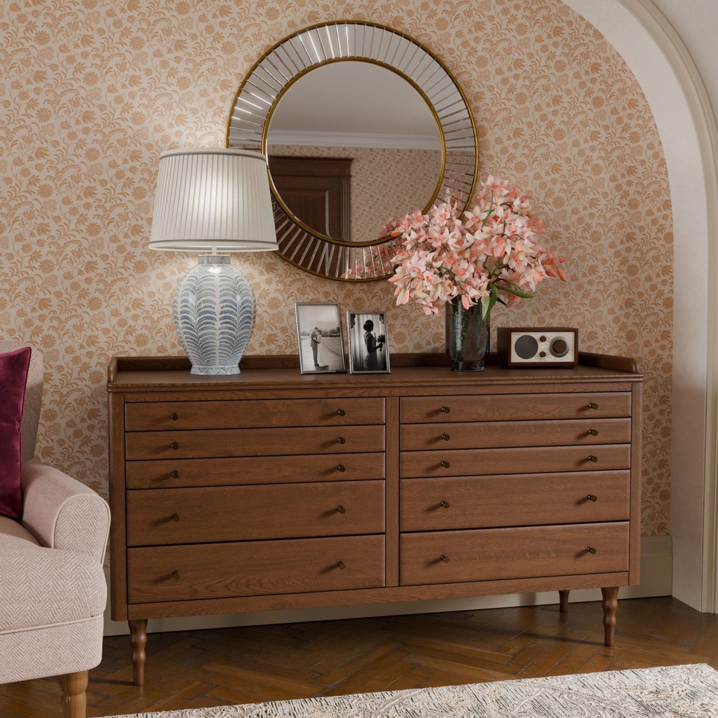 Wooden dresser with decorative items against a patterned wall.