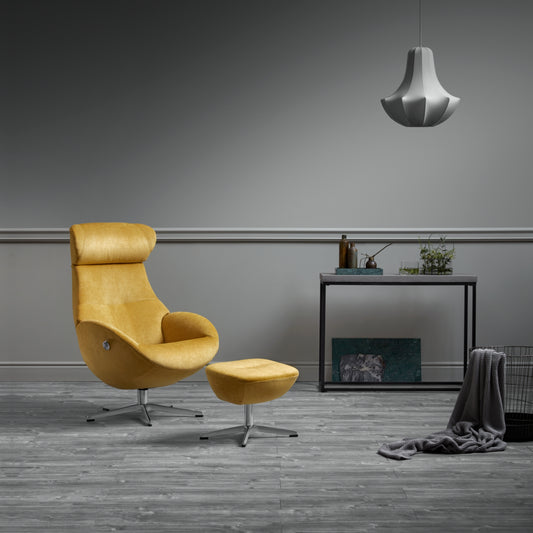 Yellow armchair and foot stool in a modern room with a grey wall and wooden floor.