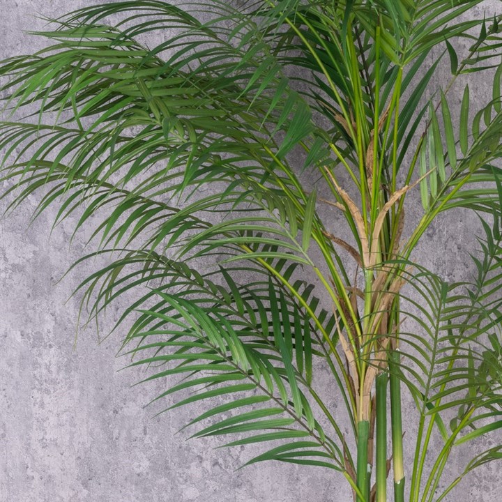 A faux areca palm plant with vibrant green leaves 